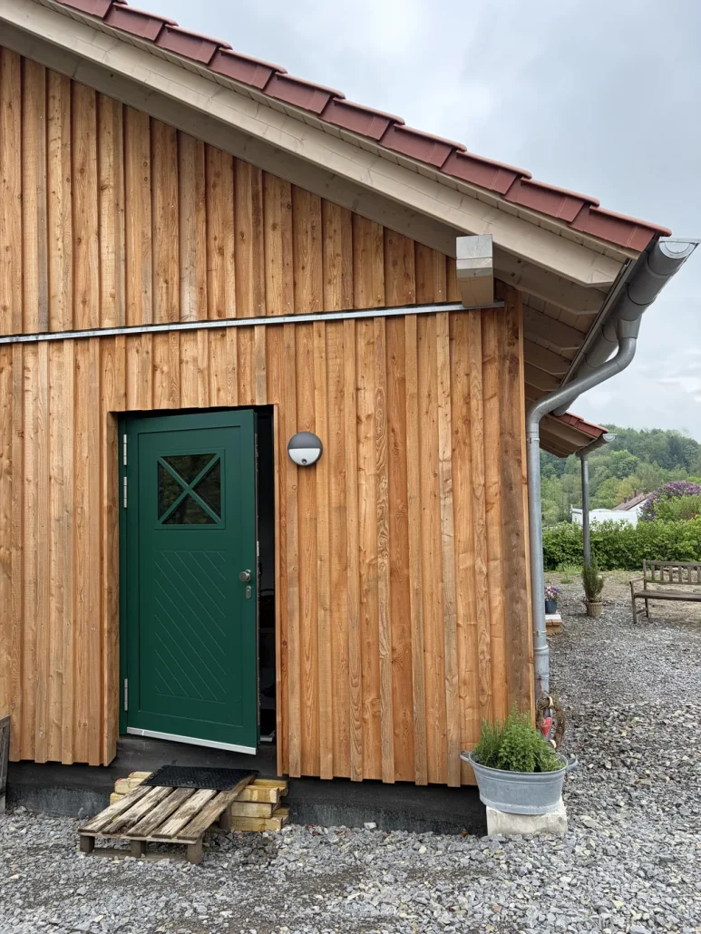 Eingangsbereich des Holzhauses mit Vordach